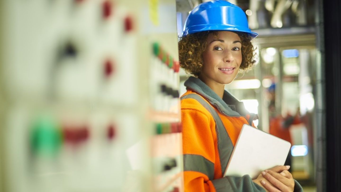 Young Spirax Sarco engineer is checking system outside on his tablet and smiling