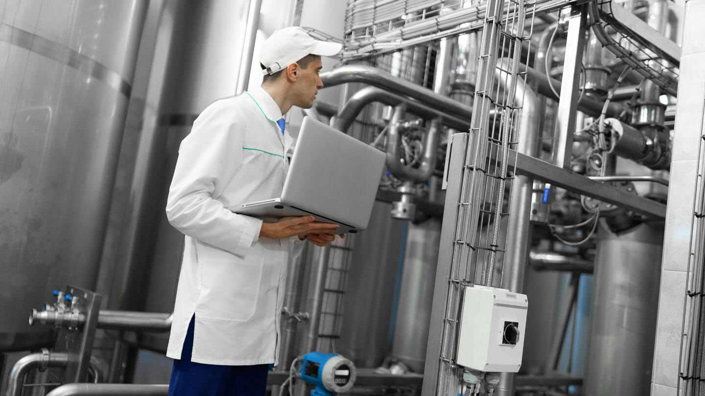 Man checking productivity targets through his laptop in a factory