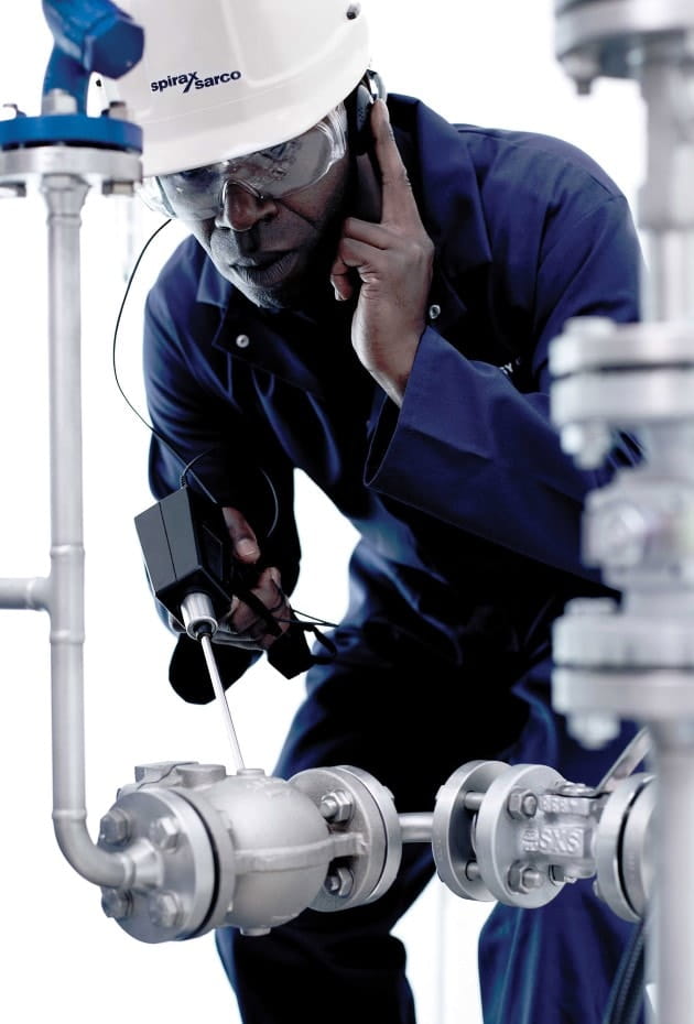 Man bent over a steam trap to check how well it is working