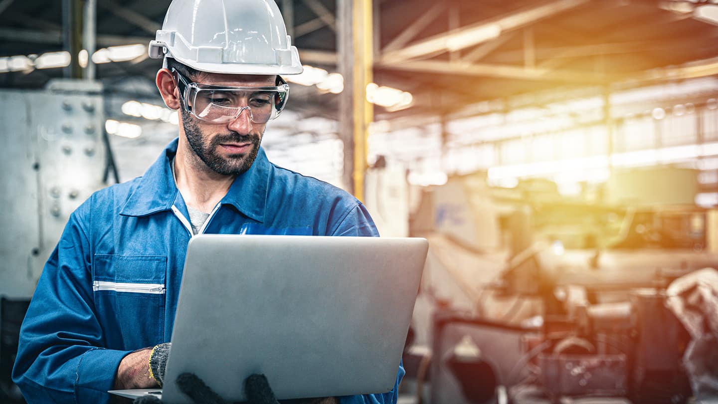 Ingenieur mit Laptop in Anlage